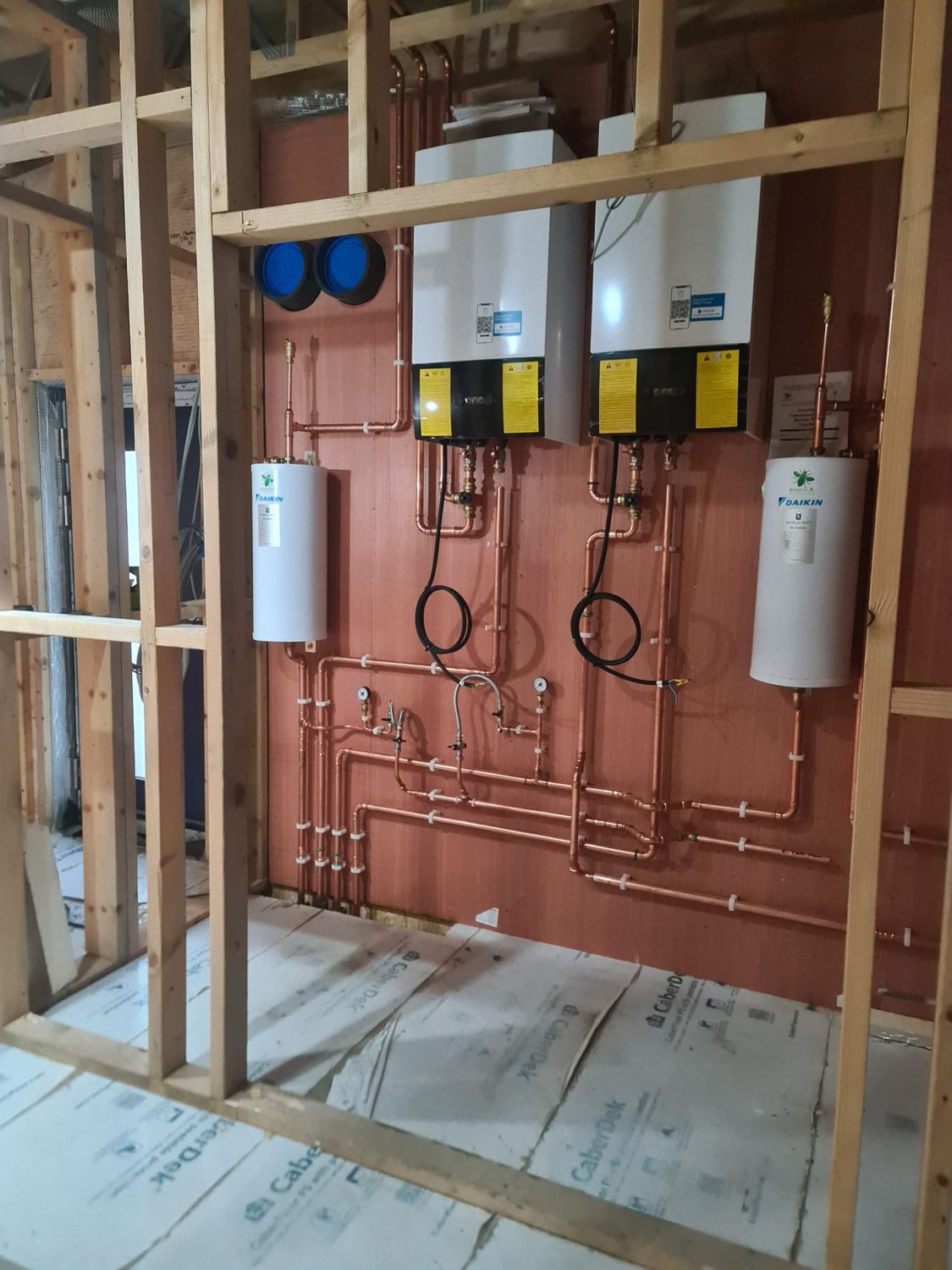 Multiple boilers and copper pipework on a plant board