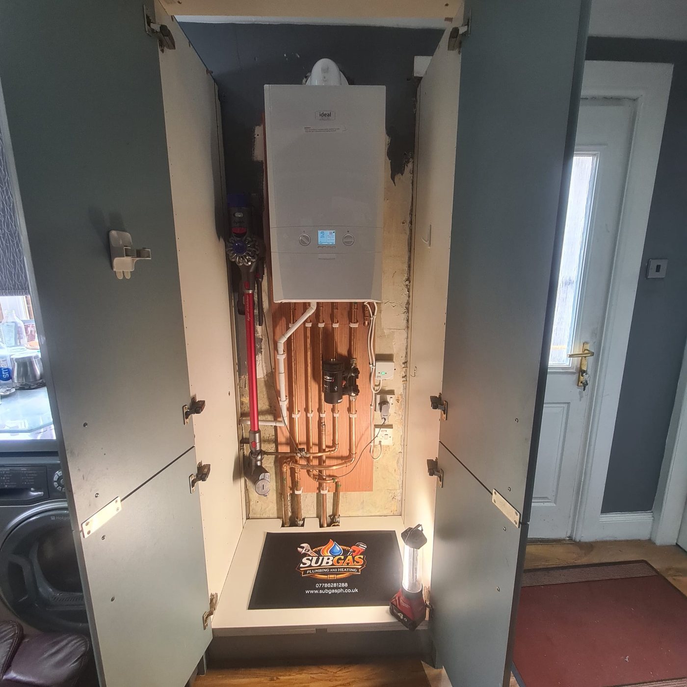 Ideal combi boiler installed in a hallway cupboard with new copper pipework and magnetic filter
